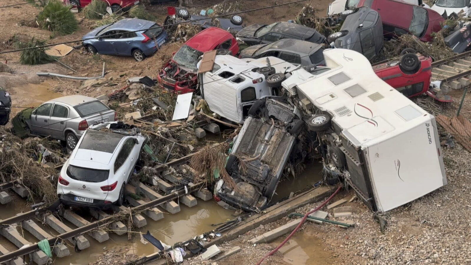 epa11692826 Damaged cars and debris are stacked in the middle of a tran rail in the flood-hit city of Alfafar, in the province of Valencia, Spain, 30 October 2024. The intense rainfall impacting the eastern part of the country resulted in at least 70 lives being lost in the province of Valencia and neighboring provinces due to the flooding. The State Meteorological Agency (AEMET) issued orange and red alerts for rainfall in multiple regions of east and southern Spain due to a DANA (isolated depression at high levels) phenomenon.  EPA/RAQUEL SEGURA