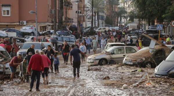 epa11692839 Residents walk along a mud-covered street in the flood-hit municipality of Paiporta, in the province of Valencia, Spain, 30 October 2024. The intense rainfall impacting the eastern part of the country resulted in at least 70 lives being lost in the province of Valencia and neighboring provinces due to the flooding. The mayor of Paiporta, located about ten kilometers southwest of Valencia, confirmed that at least 34 people died in the municipality due to the flooding. The State Meteorological Agency (AEMET) issued orange and red alerts for rainfall in multiple regions of east and southern Spain due to a DANA (isolated depression at high levels) phenomenon.  EPA/MANUEL BRUQUE