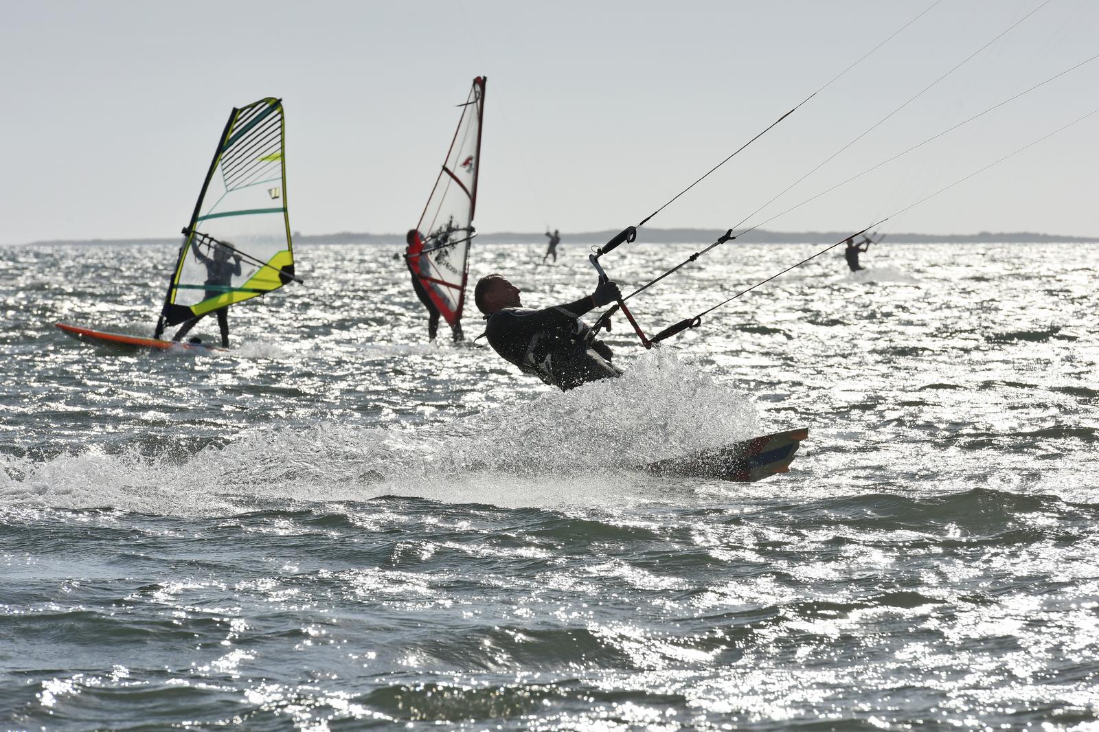 Medulin: Surferi dobro znaju kako iskoristiti jak vjetar 27.10.2018., Medulin - Na Medulinskom podrucju danas prevladava djelomice suncano do pretezno oblacno vrijeme, jugo jaca, a temperature zraka iznimno su visoke za doba godine pa surferi i kayteri iz Slovenije, Austrije, Italije i Hrvatske uzivaju "jahajuci" na valovima rPhoto: Dusko Marusic/Pixsell