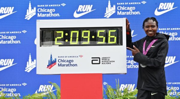 Oct 13, 2024; Chicago, IL, USA; Ruth Chepngetich of Kenya poses for a photo with the time clock after finishing first in the womens race, setting a new world record at 2:09:56 during the Chicago Marathon at Grant Park. Mandatory Credit: Patrick Gorski-Imagn Images Photo: Patrick Gorski/REUTERS