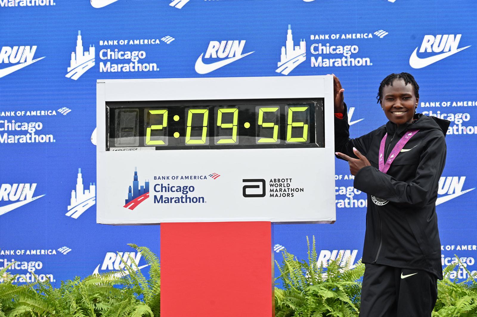 Oct 13, 2024; Chicago, IL, USA; Ruth Chepngetich of Kenya poses for a photo with the time clock after finishing first in the womens race, setting a new world record at 2:09:56 during the Chicago Marathon at Grant Park. Mandatory Credit: Patrick Gorski-Imagn Images Photo: Patrick Gorski/REUTERS