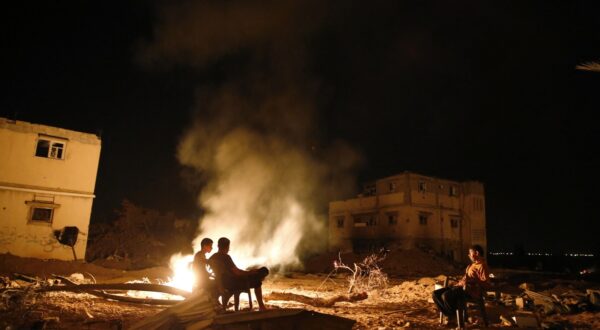 Palestinian men sit next to a fire amid destroyed homes on their block in Shejaiya on August 27, 2014. Shejaiya was one of the hardest hit neighborhoods in fighting between Hamas militants and Israel during 50 days of fighting. The fire was set by the home owners in an effort to keep mosquitoes away from their shattered homes. Israel and Palestinians both boasted of victory in the Gaza war but analysts say Hamas received only promises while the conflict aggravated divisions in the Israeli leadership.,Image: 203136918, License: Rights-managed, Restrictions: , Model Release: no, Credit line: ROBERTO SCHMIDT / AFP / Profimedia