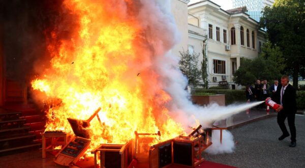 Members of the National Guard extinguish a fire set by opposition MPs by burning their Parliament chairs in front of the Parliament in protest of the arrest of their colleague opposition MP Ervin Salianji in Tirana on September 30, 2024. Leader of centre-right Democratic Party, Ervin Salianji was sentenced to one-year imprisonment and convicted of 