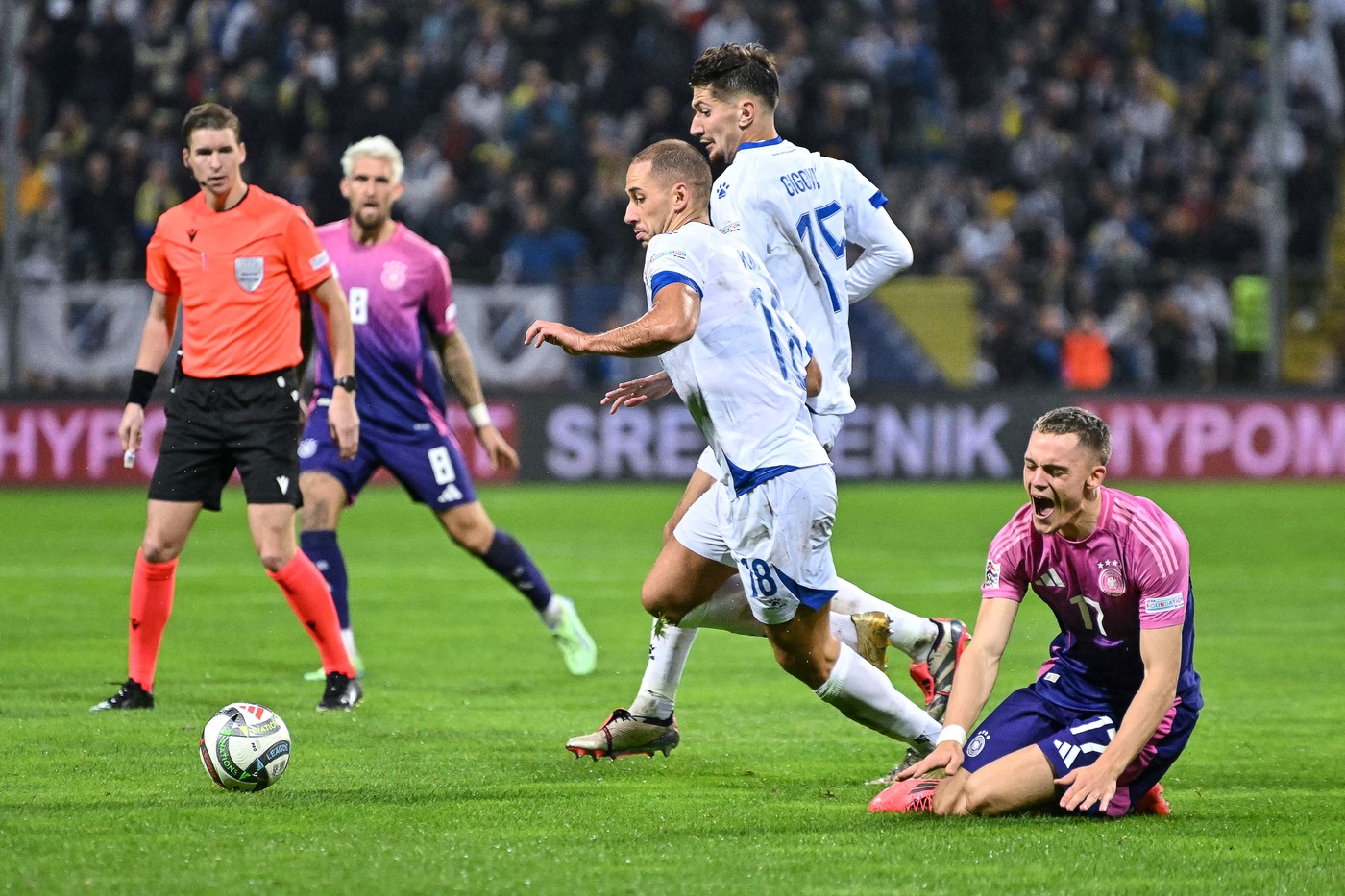 Germany's midfielder #17 Florian Wirtz (R) reacts as he fights for the ball with Bosnia and Herzegovina's defender #18 Nikola Katic (L) and Bosnia and Herzegovina's midfielder #15 Armin Gigovic (C)  during the UEFA Nations League, League A - Group 3, football match between Bosnia and Herzegovina and Germany at the Bilino Polje Stadium in Zenica, on October 11, 2024.,Image: 919763979, License: Rights-managed, Restrictions: , Model Release: no, Credit line: Elvis Barukcic / AFP / Profimedia