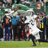 Philadelphia Eagles running back Saquon Barkley (26) hurdles over Jacksonville Jaguars cornerback Jarrian Jones (22) during the first half of an NFL football game Sunday, Nov. 3, 2024, in Philadelphia. (AP Photo/Chris Szagola)