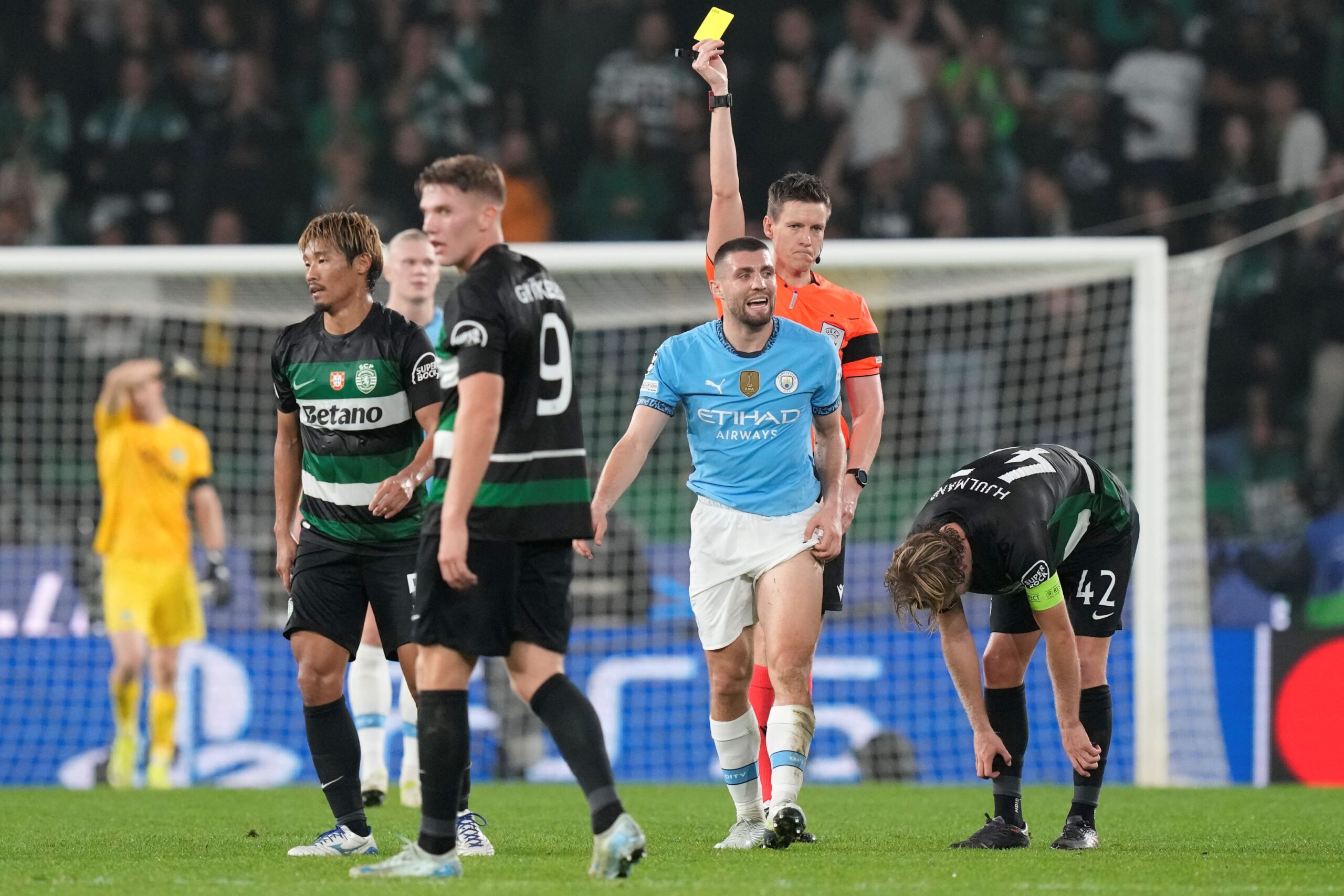 Manchester City's Mateo Kovacic, center, receives a yellow card during the UEFA Champions League opening phase match between Sporting and Manchester City in Lisbon, Portugal, Tuesday, Nov. 5, 2024. (AP Photo/Armando Franca) Portugal Soccer Champions League