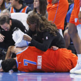 Oklahoma City Thunder staff help Thunder forward Chet Holmgren (7) after he was injured during the first half of an NBA basketball game against the Golden State Warriors, Sunday, Nov. 10, 2024, in Oklahoma City. (AP Photo/Nate Billings)