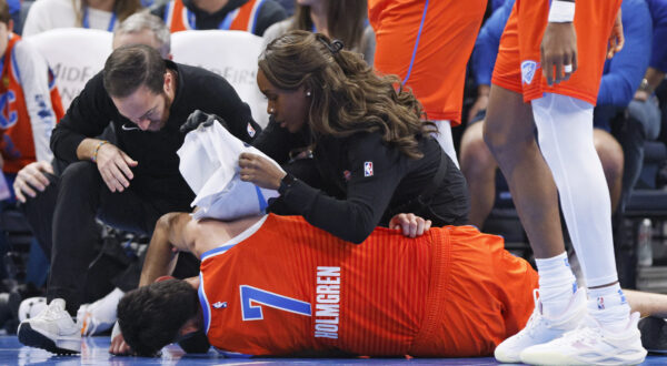 Oklahoma City Thunder staff help Thunder forward Chet Holmgren (7) after he was injured during the first half of an NBA basketball game against the Golden State Warriors, Sunday, Nov. 10, 2024, in Oklahoma City. (AP Photo/Nate Billings)