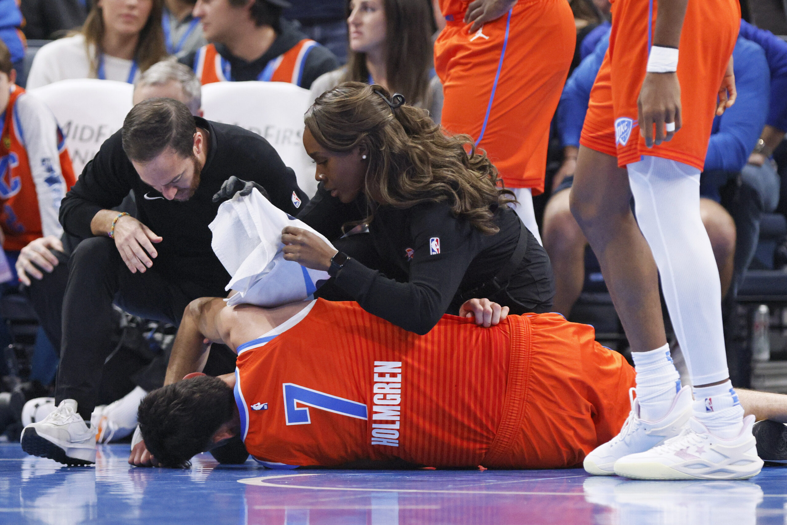 Oklahoma City Thunder staff help Thunder forward Chet Holmgren (7) after he was injured during the first half of an NBA basketball game against the Golden State Warriors, Sunday, Nov. 10, 2024, in Oklahoma City. (AP Photo/Nate Billings)