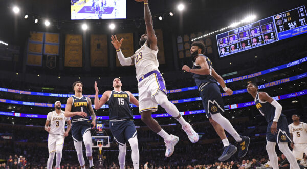 Los Angeles Lakers forward LeBron James (23) shoots as Denver Nuggets forward Michael Porter Jr. (1), center Nikola Jokic (15), guard Jamal Murray (27) and forward Michael Porter Jr. (1) defend during the first half of an NBA basketball game, Saturday, Nov. 23, 2024, in Los Angeles. (AP Photo/Mark J. Terrill)