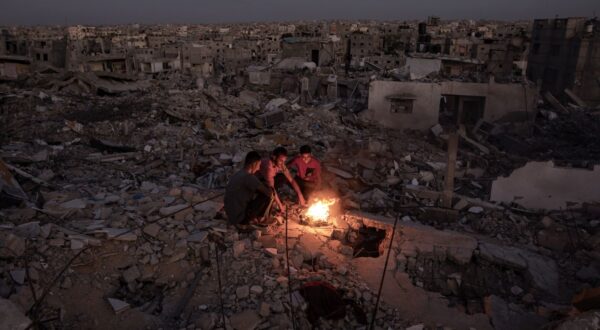 epa11671648 Palestinians sit next to a fire on the rubble of their destroyed home in Khan Yunis, southern Gaza Strip, 20 October 2024. More than 42,500 Palestinians and over 1,400 Israelis have been killed, according to the Palestinian Health Ministry and the Israel Defense Forces (IDF), since Hamas militants launched an attack against Israel from the Gaza Strip on 07 October 2023, and the Israeli operations in Gaza and the West Bank that followed it.  EPA/HAITHAM IMAD