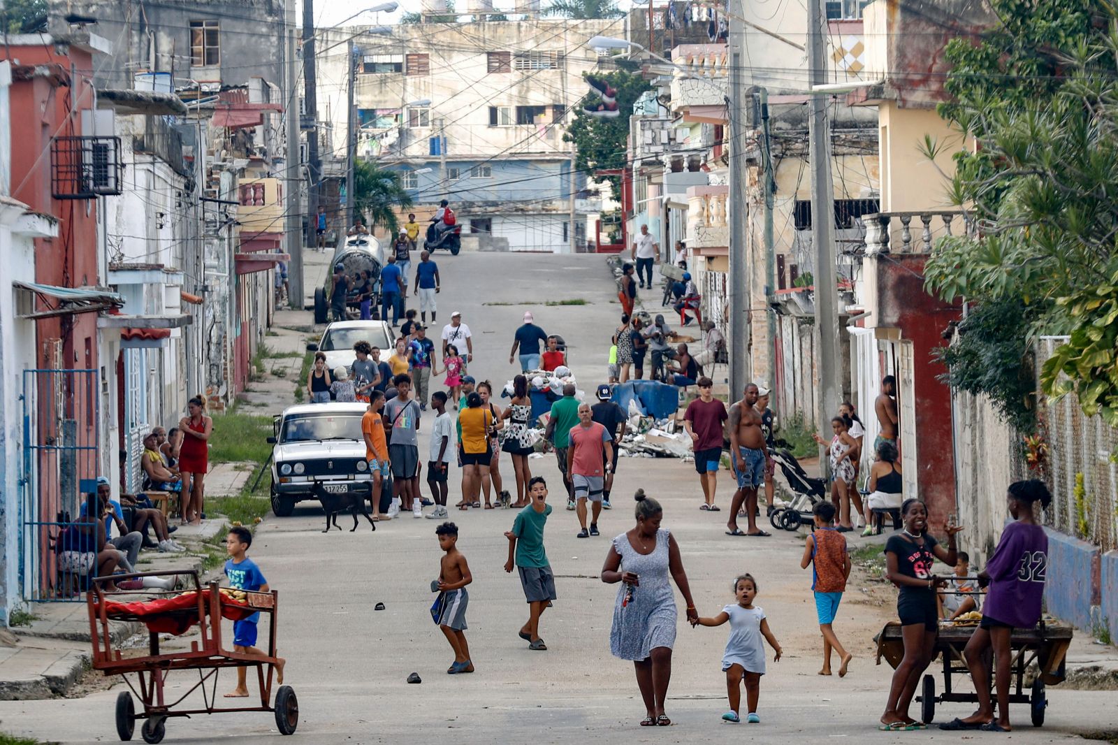 epa11673399 People walk down a street during a national blackout in Havana, Cuba, 20 October 2024 (issued 21 October 2024). Cuba's Ministry of Energy and Mines reported on 20 October a third total failure of the National Electric System (SEN) in less than three days. Cuba's state-run Union Electrica (UNE) on 21 October said that around 50 percent of Havana's residents now have power supply, after almost 72 hours of the total blackout registered on the island.  EPA/YANDER ZAMORA