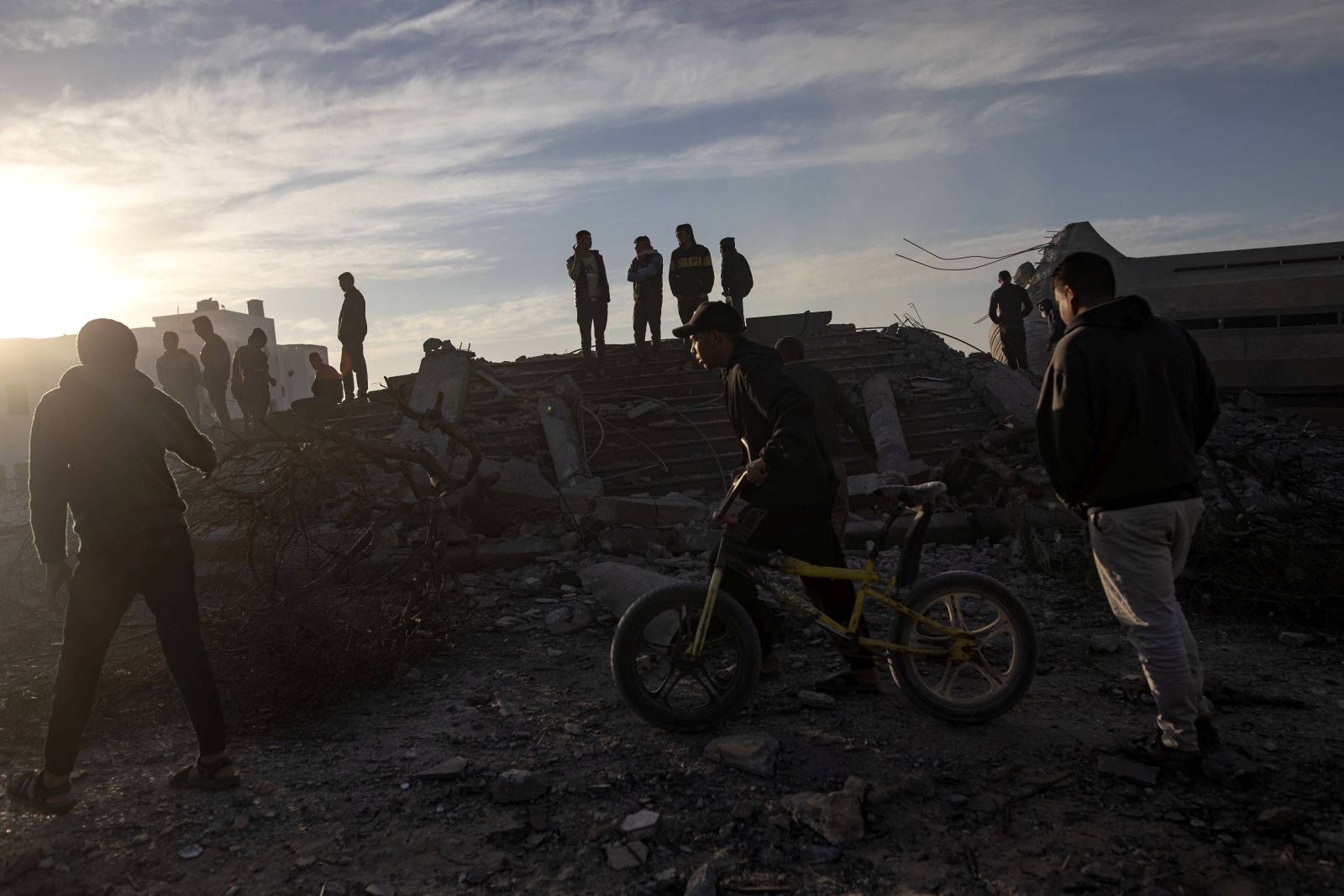 epa11682114 Palestinians walk next to the remains of destroyed buildings following the Israeli airstrikes in Khan Younis, southern Gaza Strip, 25 October 2024. More than 42,800 Palestinians and over 1,400 Israelis have been killed, according to the Palestinian Health Ministry and the Israel Defense Forces (IDF), since Hamas militants launched an attack against Israel from the Gaza Strip on 07 October 2023, and the Israeli operations in Gaza and the West Bank which followed it.  EPA/HAITHAM IMAD