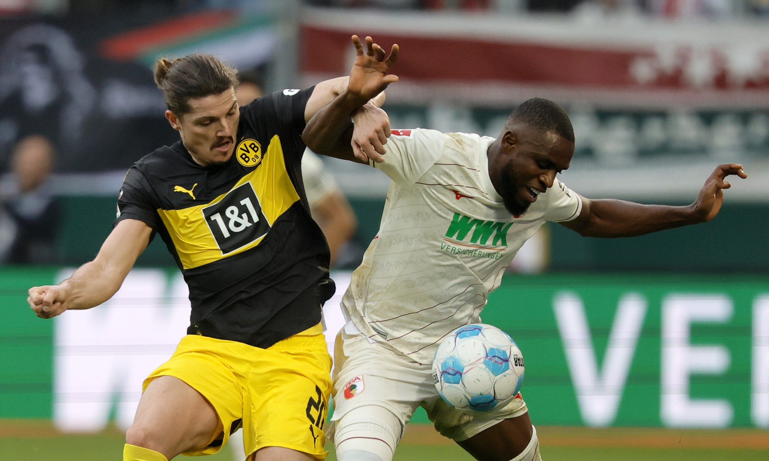 epa11684962 Ogochukwu Frank Onyeka of Augsburg (R) in action against Marcel Sabitzer of Dortmund (L) during the German Bundesliga soccer match between FC Augsburg and Borussia Dortmund in Augsburg, Germany, 26 October 2024.  EPA/RONALD WITTEK CONDITIONS - ATTENTION: The DFL regulations prohibit any use of photographs as image sequences and/or quasi-video.