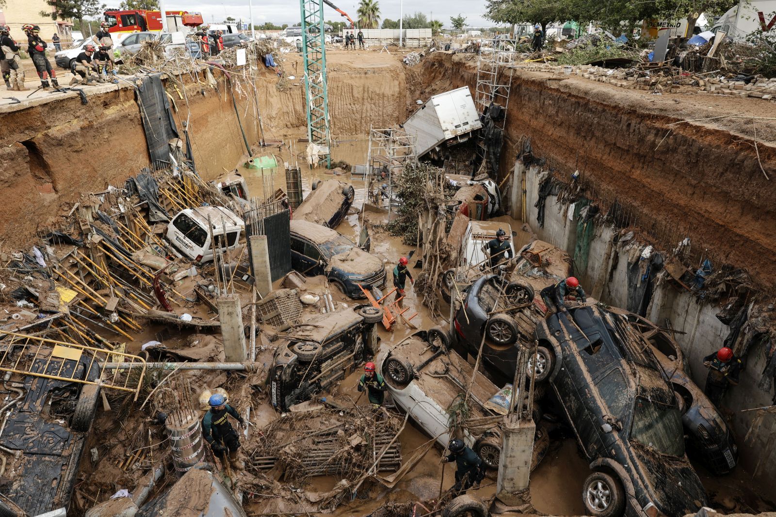 epa11696955 Civil Guard officers search for survivors inside cars trapped under the foundations of a building under construction in the town of Paiporta, Valencia, eastern Spain, 02 November 2024. According to the Integrated Operational Coordination Center (CECOPI), more than 200 people have died in Valencia and neighboring provinces after floods caused by a DANA (high-altitude isolated depression) weather phenomenon hit the east of the country. According to Spain's national weather agency (AEMET), on 29 October 2024 Valencia received a year's worth of rain, causing flash floods that destroyed homes and swept away vehicles.  EPA/Biel Alino