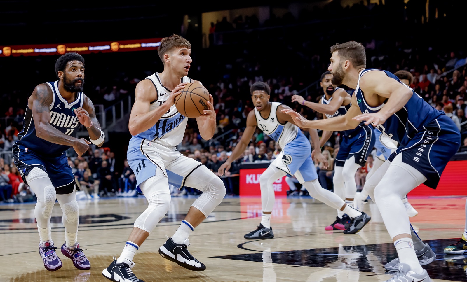 epa11740813 Atlanta Hawks guard Bogdan Bogdanovic (C) of Serbia in action against Dallas Mavericks guard Kyrie Irving (L) and Dallas Mavericks forward Maxi Kleber (R) of Germany during the second half  of an NBA basketball game between the Dallas Mavericks and the Atlanta Hawks in Atlanta, Georgia, USA, 25 November 2024.  EPA/ERIK S. LESSER  SHUTTERSTOCK OUT