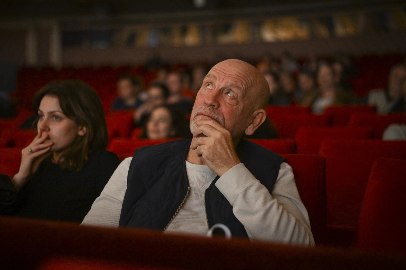 This picture taken on November 6, 2024, shows US actor John Malkovich watching the dress rehearsal for the play "Arms and the Man" which he directed at the Bulgarian National Theatre in Sofia. A 19th century play directed by US actor John Malkovich has caused a stir in Bulgaria, with critics slamming what they called the "insulting" portrayal of Bulgarians in the production. Last week's premiere of "Arms and the Man" by renowned Irish-born playwright George Bernard Shaw sparked raucous protests among nationalist groups. Holding up banners that read "Malkovich go home", angry protesters blocked access to the National theatre in the capital Sofia before attempting to storm it, accusing the 70-year-old director of ridiculing the country's history and its citizens.,Image: 933270631, License: Rights-managed, Restrictions: TO GO WITH AFP STORY BY Vessela SERGUEVA, Model Release: no, Credit line: Nikolay DOYCHINOV / AFP / Profimedia