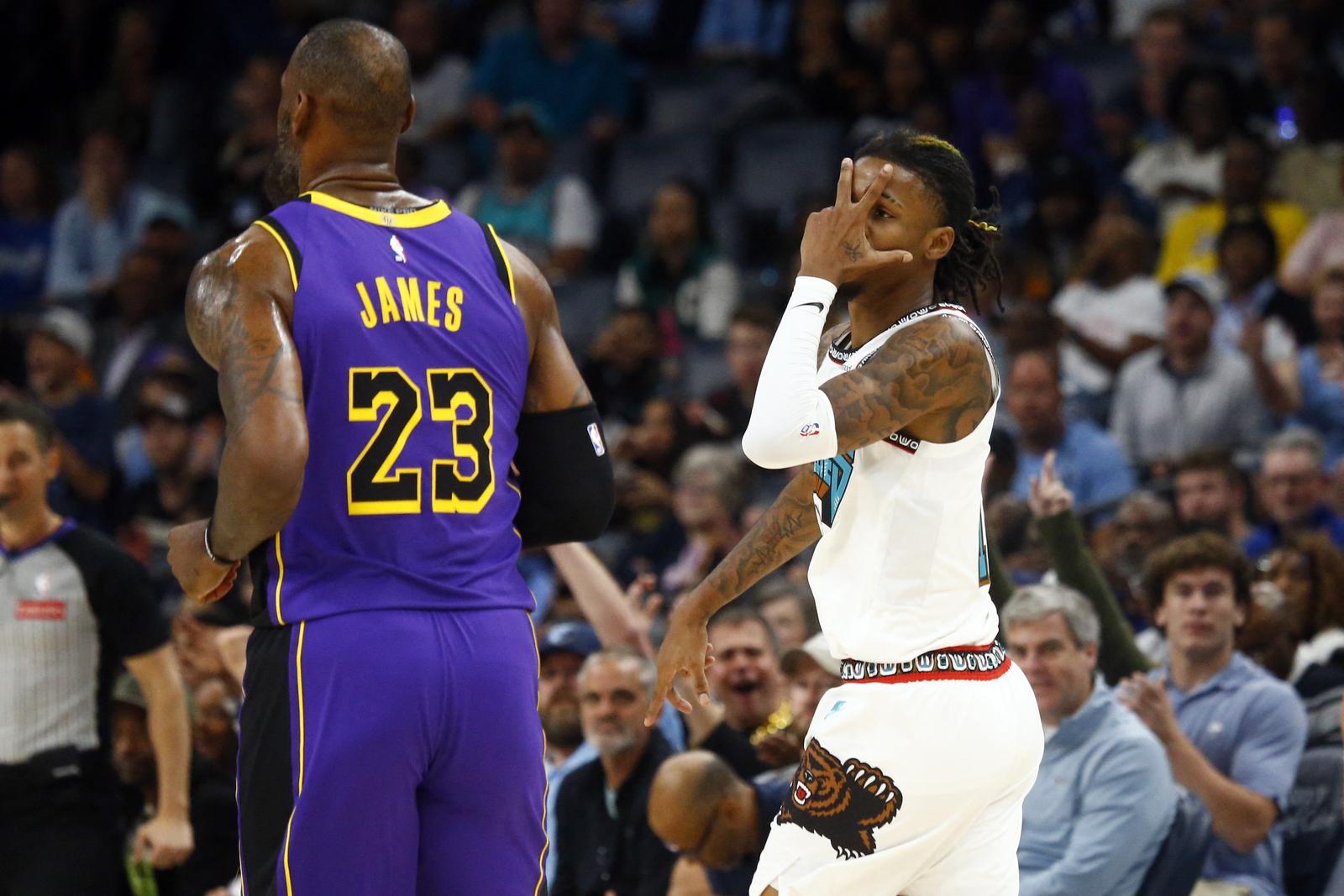 Nov 6, 2024; Memphis, Tennessee, USA; Memphis Grizzlies guard Ja Morant (12) reacts toward Los Angeles Lakers forward LeBron James (23) after a three point basket during the first half at FedExForum. Mandatory Credit: Petre Thomas-Imagn Images Photo: Petre Thomas/REUTERS