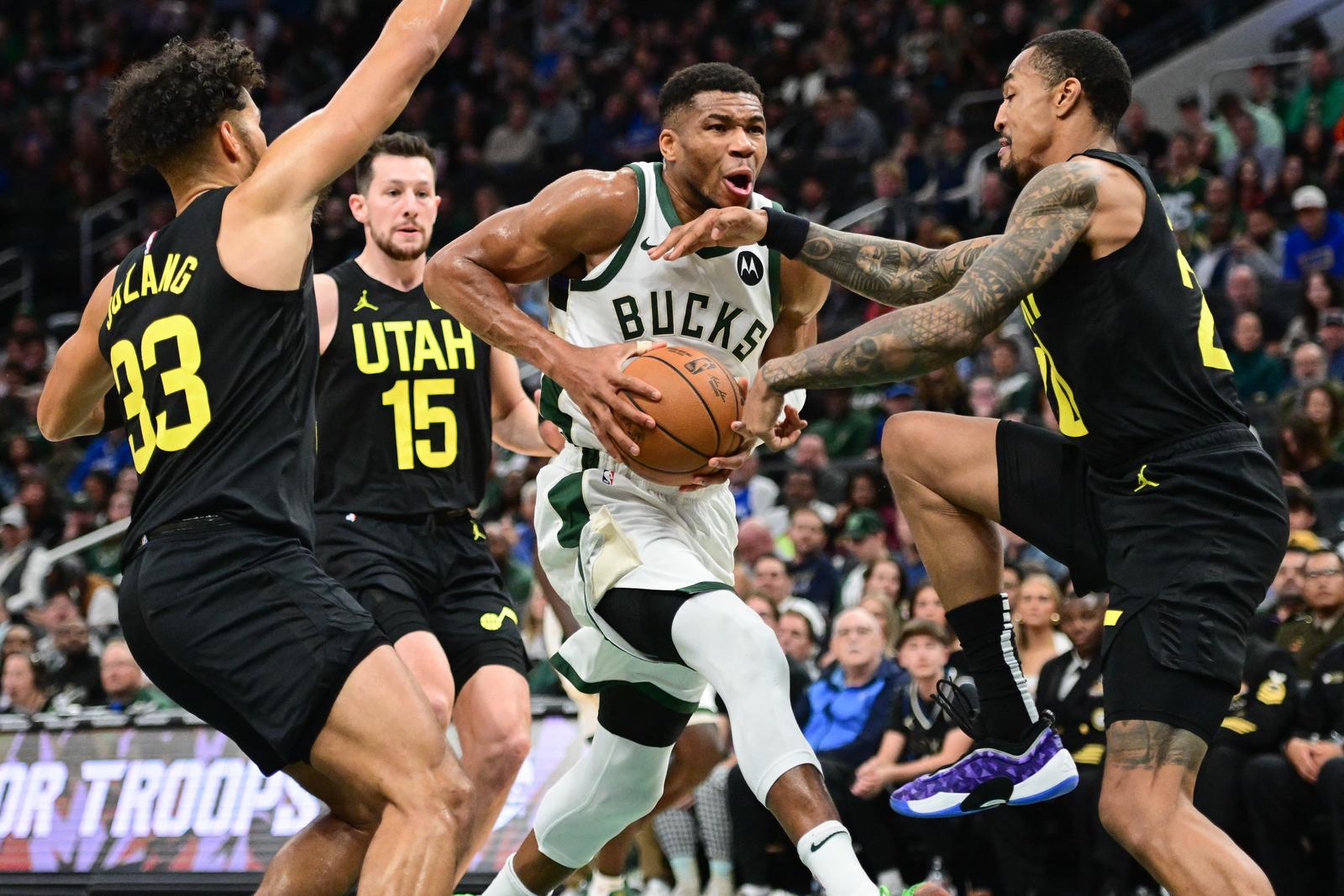 Nov 7, 2024; Milwaukee, Wisconsin, USA; Milwaukee Bucks forward Giannis Antetokounmpo (34) drives for the basket against Utah Jazz guard Johnny Juzang (33), forward Drew Eubanks (15) and center John Collins (20) in the fourth quarter at Fiserv Forum. Mandatory Credit: Benny Sieu-Imagn Images Photo: Benny Sieu/REUTERS