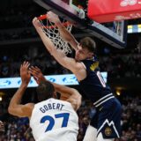 Apr 10, 2024; Denver, Colorado, USA; Denver Nuggets guard Christian Braun (0) finishes off a dunk over Minnesota Timberwolves center Rudy Gobert (27) and guard Anthony Edwards (5)  in the second half at Ball Arena. Mandatory Credit: Ron Chenoy-USA TODAY Sports Photo: Ron Chenoy/REUTERS