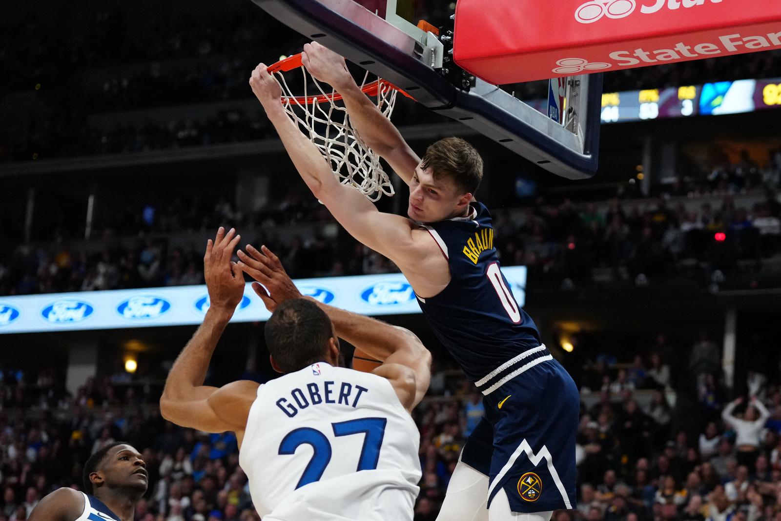 Apr 10, 2024; Denver, Colorado, USA; Denver Nuggets guard Christian Braun (0) finishes off a dunk over Minnesota Timberwolves center Rudy Gobert (27) and guard Anthony Edwards (5)  in the second half at Ball Arena. Mandatory Credit: Ron Chenoy-USA TODAY Sports Photo: Ron Chenoy/REUTERS