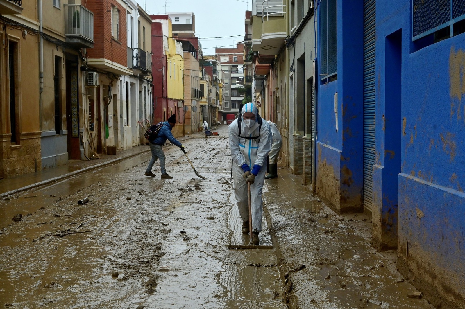 A man wearing protective jumpsuit takes part in cleaning works in a street covered in mud in Paiporta, south of Valencia, eastern Spain, on November 13, 2024 in the aftermath of deadly flooding. Spain closed schools and evacuated residents as heavy rains lashed the country on November 13, two weeks after its worst floods in a generation killed more than 200 people.,Image: 933936629, License: Rights-managed, Restrictions: , Model Release: no, Credit line: JOSE JORDAN / AFP / Profimedia