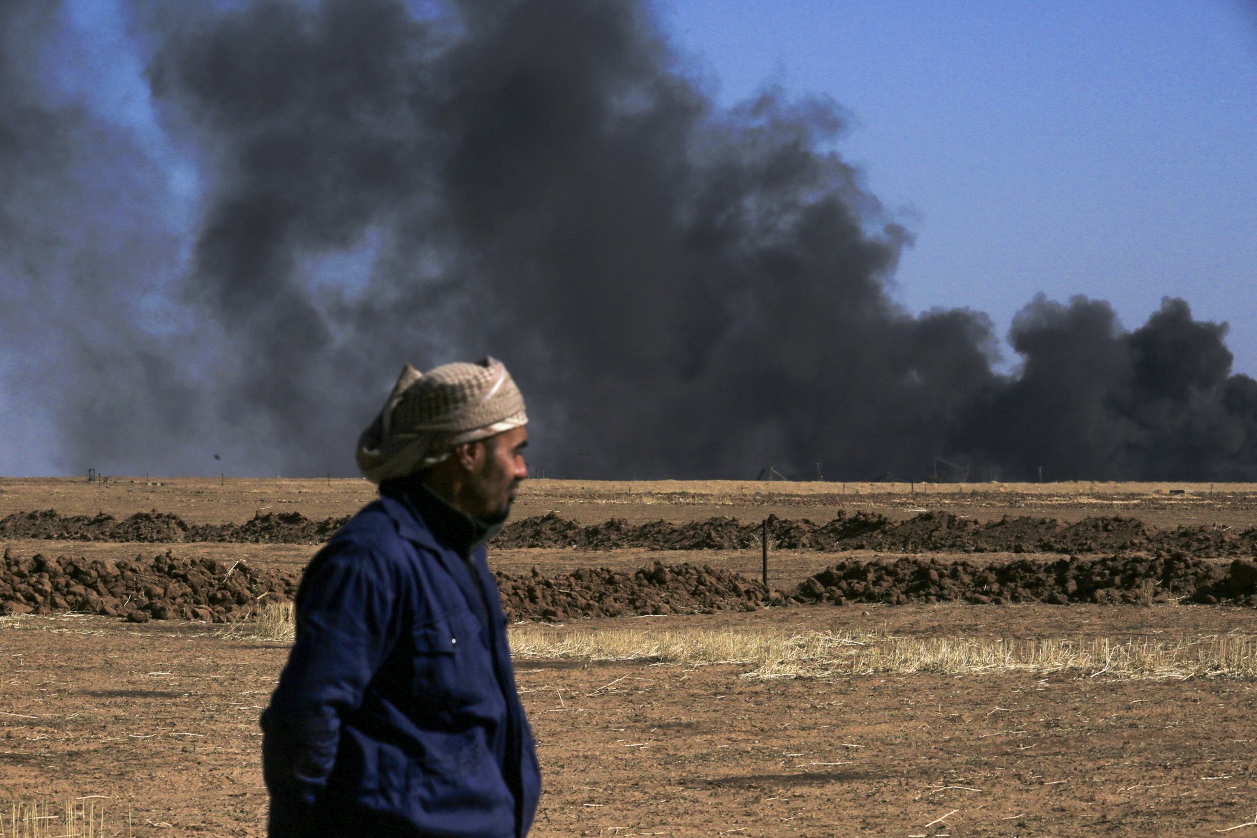 A man looks on as thick smoke rises from an oil extracting facility targeted by Turkish shelling near Syria's northeastern border with Turkey in the Qahtaniyah countryside in the far northeast corner of Hasakeh province on October 25, 2024. A Syria war monitor said on October 25 that Turkish drone strikes had killed 27 civilians in Syria in a 24-hour military escalation, following a deadly attack on a defence company near Ankara.,Image: 926194377, License: Rights-managed, Restrictions: , Model Release: no, Credit line: Delil SOULEIMAN / AFP / Profimedia