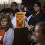 A woman in the audience holds up a poster with a message of support for immigrants as the Los Angeles City Council considers a "sanctuary city" ordinance during a meeting at City Hall in Los Angeles, California, on November 19, 2024.  The proposed sanctuary city ordinance would prohibit any city resources from being used  to help federal enforcement of immigration laws.,Image: 936525210, License: Rights-managed, Restrictions: , Model Release: no, Credit line: ETIENNE LAURENT / AFP / Profimedia