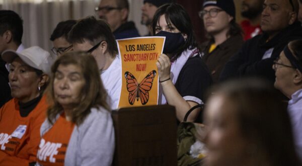 A woman in the audience holds up a poster with a message of support for immigrants as the Los Angeles City Council considers a "sanctuary city" ordinance during a meeting at City Hall in Los Angeles, California, on November 19, 2024.  The proposed sanctuary city ordinance would prohibit any city resources from being used  to help federal enforcement of immigration laws.,Image: 936525210, License: Rights-managed, Restrictions: , Model Release: no, Credit line: ETIENNE LAURENT / AFP / Profimedia