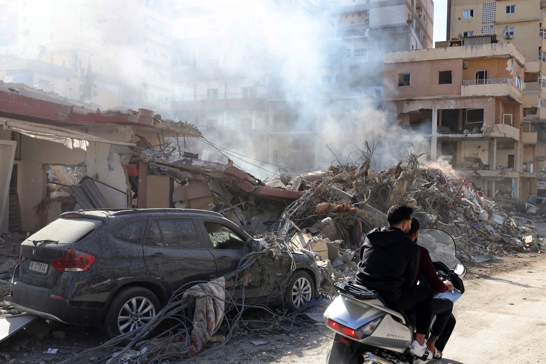 Residents ride a scooter amid destruction caused by Israeli bombing in the southern Lebanese city of Tyre on November 28, 2024, a day after a cease fire between Israel and Hezbollah took hold.  Since the ceasefire took effect on November 27, tens of thousands of Lebanese who fled their homes headed back to their towns and villages, only to find scenes of devastation.,Image: 940413177, License: Rights-managed, Restrictions: , Model Release: no, Credit line: Anwar AMRO / AFP / Profimedia