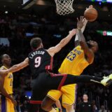 Miami Heat guard Pelle Larsson (9) fouls Los Angeles Lakers forward LeBron James (23) during the first half of an NBA basketball game, Wednesday, Dec. 4, 2024, in Miami. (AP Photo/Marta Lavandier) Lakers Heat Basketball