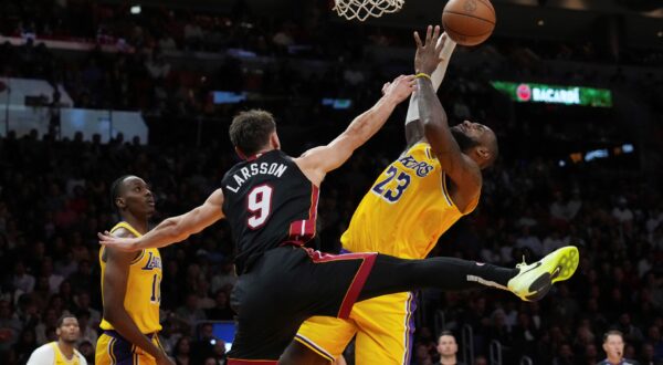 Miami Heat guard Pelle Larsson (9) fouls Los Angeles Lakers forward LeBron James (23) during the first half of an NBA basketball game, Wednesday, Dec. 4, 2024, in Miami. (AP Photo/Marta Lavandier) Lakers Heat Basketball