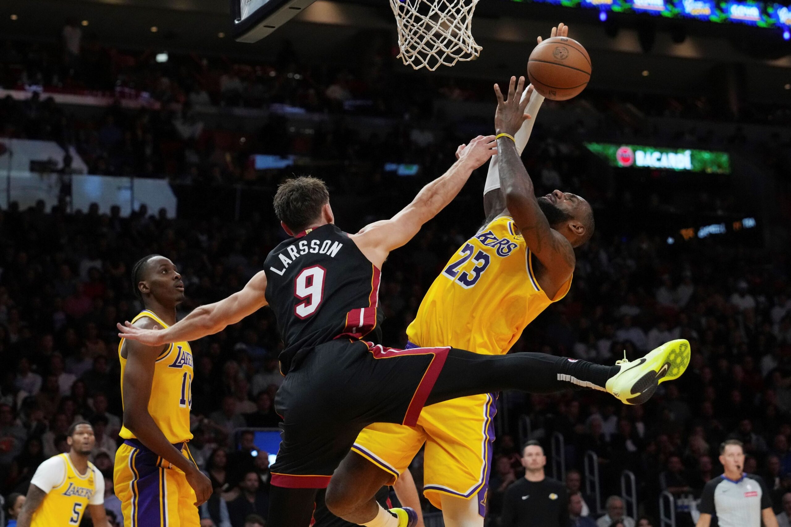 Miami Heat guard Pelle Larsson (9) fouls Los Angeles Lakers forward LeBron James (23) during the first half of an NBA basketball game, Wednesday, Dec. 4, 2024, in Miami. (AP Photo/Marta Lavandier) Lakers Heat Basketball