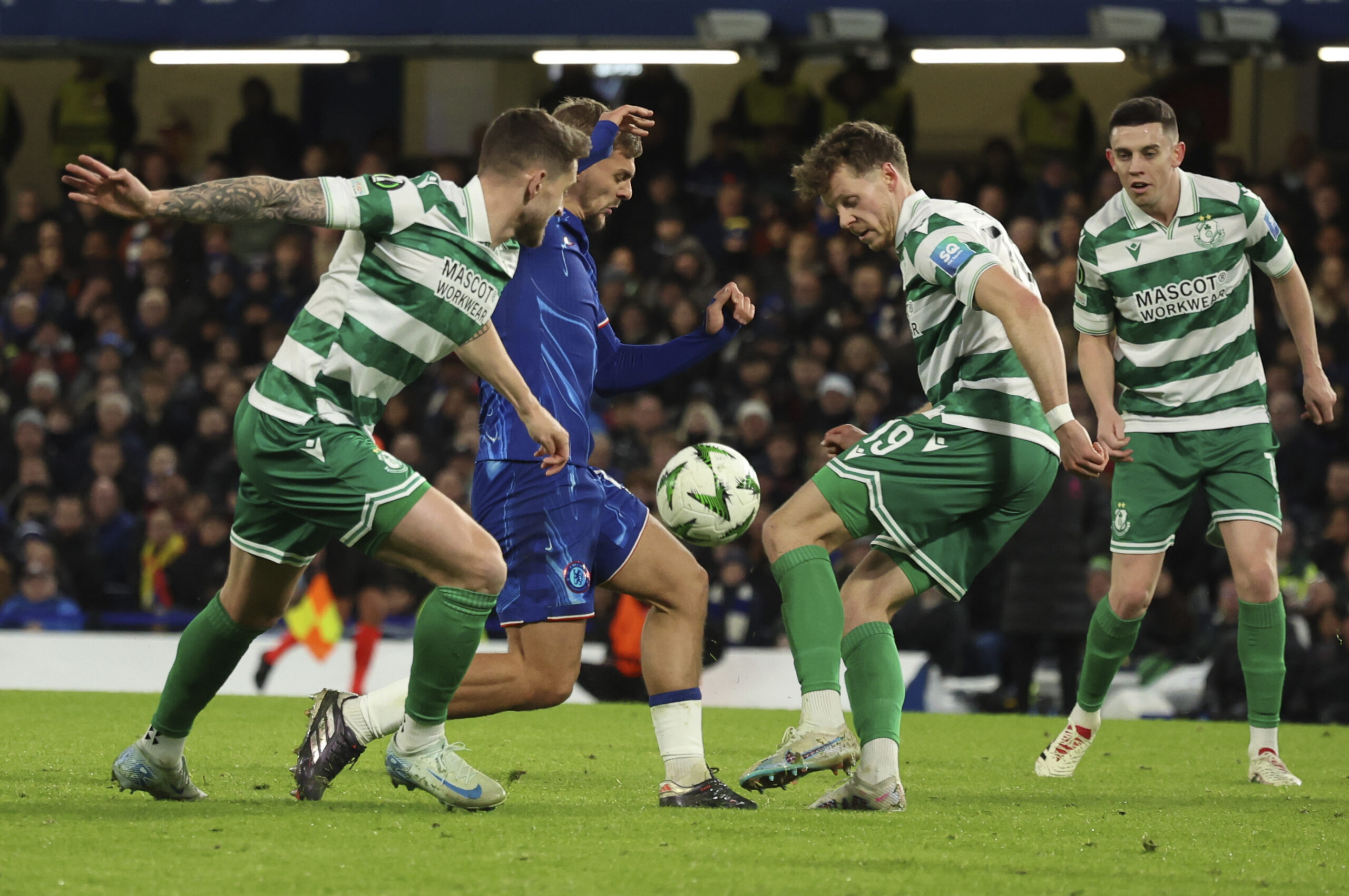 Chelsea's Kiernan Dewsbury-Hall, second from left, and Shamrock Rovers's Markus Poom vie for the ball during the Europa Conference League opening phase soccer match between Chelsea and Shamrock Rovers at Stamford Bridge stadium in London, Thursday, Dec. 19, 2024. (AP Photo/Ian Walton)