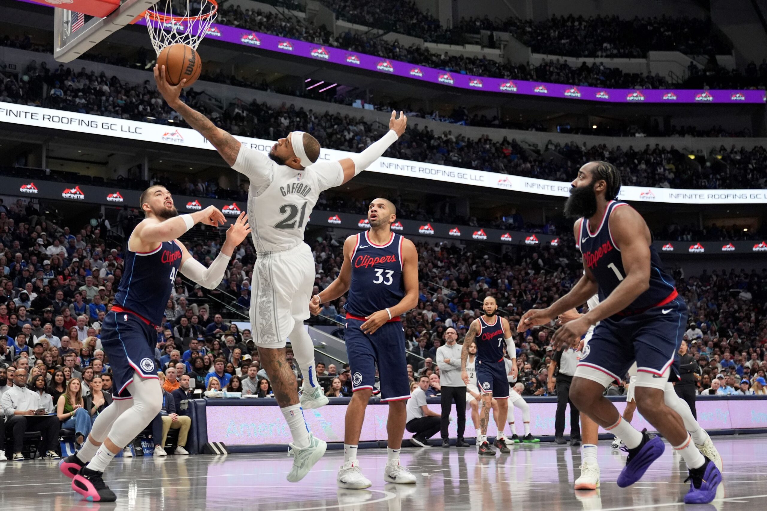 Dallas Mavericks center Daniel Gafford (21) grabs a rebound in front of Los Angeles Clippers' Ivica Zubac, left, Nicolas Batum (33) and James Harden (1) in the second half of an NBA basketball game in Dallas, Thursday, Dec. 19, 2024. (AP Photo/Tony Gutierrez) Clippers Mavericks Basketball