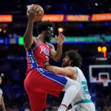 Philadelphia 76ers' Joel Embiid left, tries to go up for a shot against Charlotte Hornets' Vasilije Micic during the second half of an NBA basketball game, Friday, Dec. 20, 2024, in Philadelphia. (AP Photo/Matt Slocum) Hornets 76ers Basketball