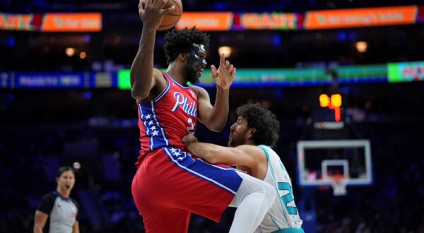 Philadelphia 76ers' Joel Embiid left, tries to go up for a shot against Charlotte Hornets' Vasilije Micic during the second half of an NBA basketball game, Friday, Dec. 20, 2024, in Philadelphia. (AP Photo/Matt Slocum) Hornets 76ers Basketball