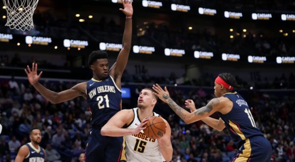 Denver Nuggets center Nikola Jokic (15) goes to the basket between New Orleans Pelicans center Yves Missi (21) and guard Brandon Boston (11) in the second half of an NBA basketball game in New Orleans, Sunday, Dec. 22, 2024. The Nuggets won in overtime 132-129. (AP Photo/Gerald Herbert) Nuggets Pelicans Basketball