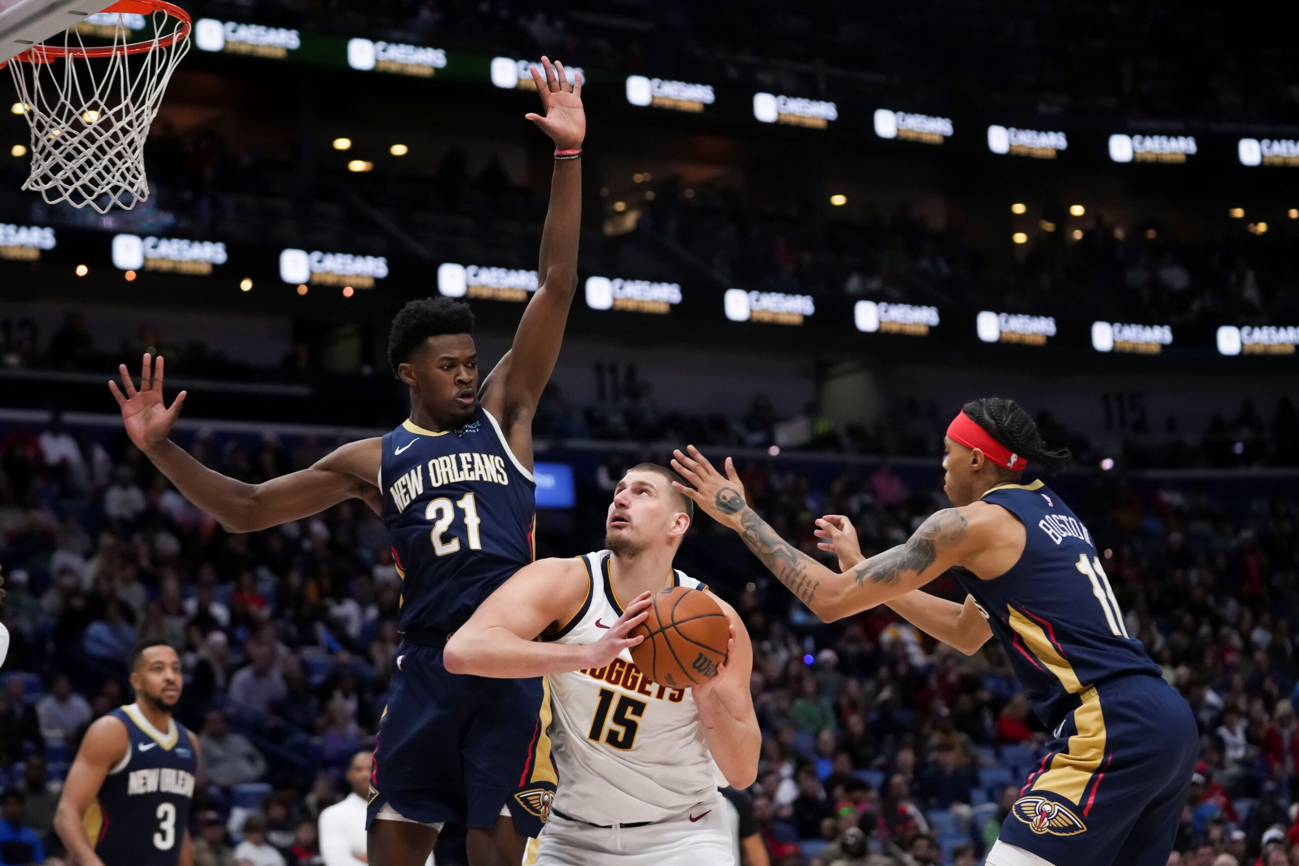 Denver Nuggets center Nikola Jokic (15) goes to the basket between New Orleans Pelicans center Yves Missi (21) and guard Brandon Boston (11) in the second half of an NBA basketball game in New Orleans, Sunday, Dec. 22, 2024. The Nuggets won in overtime 132-129. (AP Photo/Gerald Herbert) Nuggets Pelicans Basketball