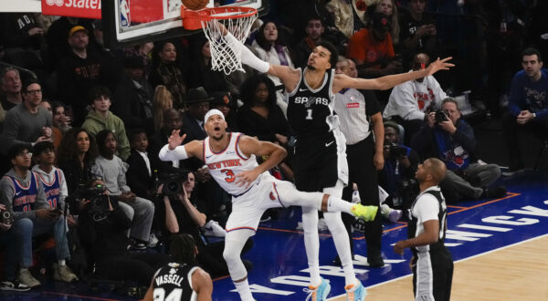 San Antonio Spurs' Victor Wembanyama (1), top right, commits goaltending on a shot put up by New York Knicks' Josh Hart (3), top left, during the first half of an NBA basketball game, Wednesday, Dec. 25, 2024, in New York. (AP Photo/Seth Wenig)