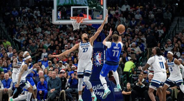 Dallas Mavericks guard Luka Doncic (77) attempts a shot over Minnesota Timberwolves center Rudy Gobert (27) in the first half of an NBA basketball game on Wednesday, Dec. 25, 2024, in Dallas. (AP Photo/Emil T. Lippe) Timberwolves Mavericks Basketball