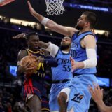 Golden State Warriors guard Dennis Schroder, left, drives against Los Angeles Clippers forward Derrick Jones Jr., center, and center Ivica Zubac during the first half of an NBA basketball game Friday, Dec. 27, 2024, in Inglewood, Calif. (AP Photo/Ryan Sun) Warriors Clippers Basketball