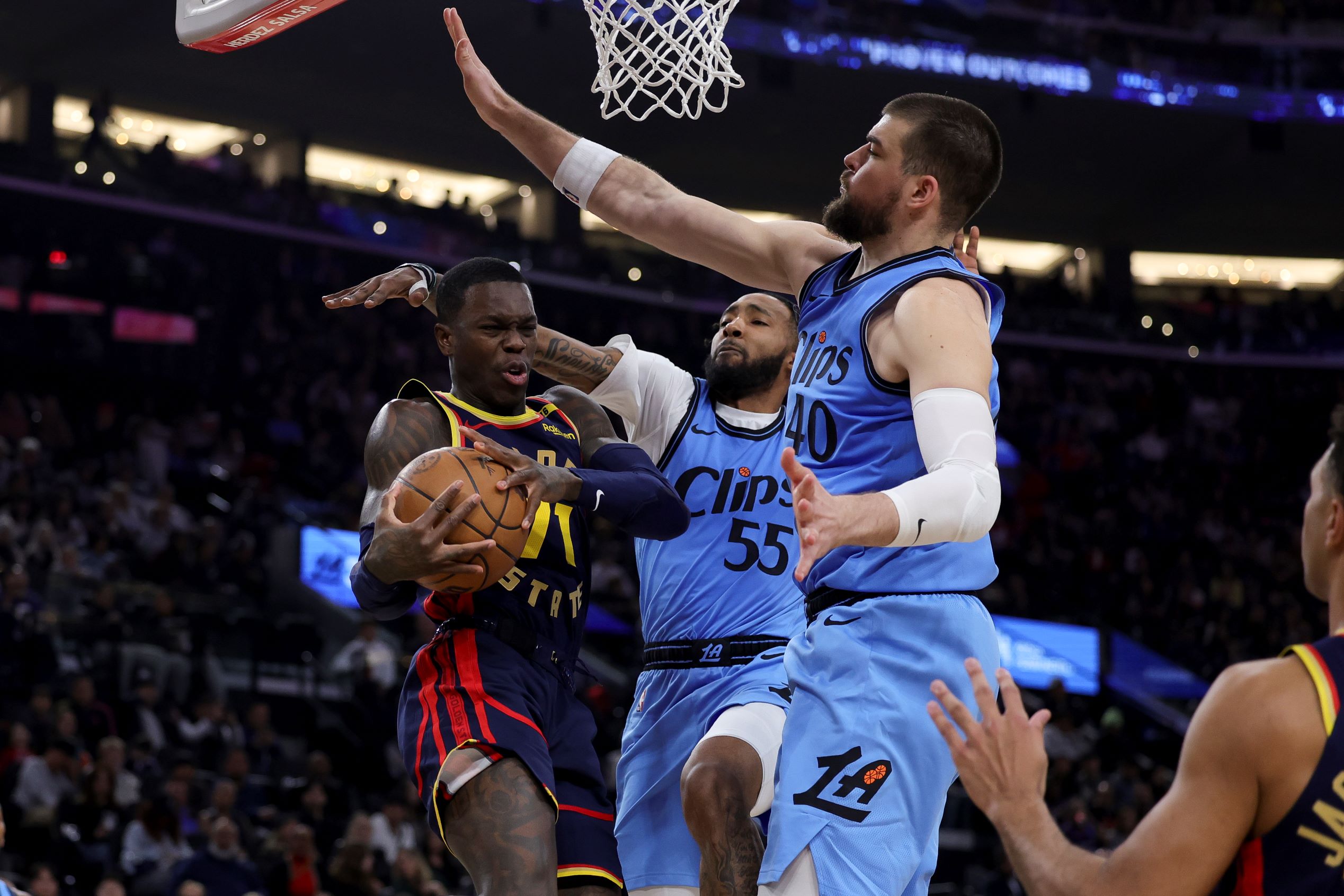 Golden State Warriors guard Dennis Schroder, left, drives against Los Angeles Clippers forward Derrick Jones Jr., center, and center Ivica Zubac during the first half of an NBA basketball game Friday, Dec. 27, 2024, in Inglewood, Calif. (AP Photo/Ryan Sun) Warriors Clippers Basketball