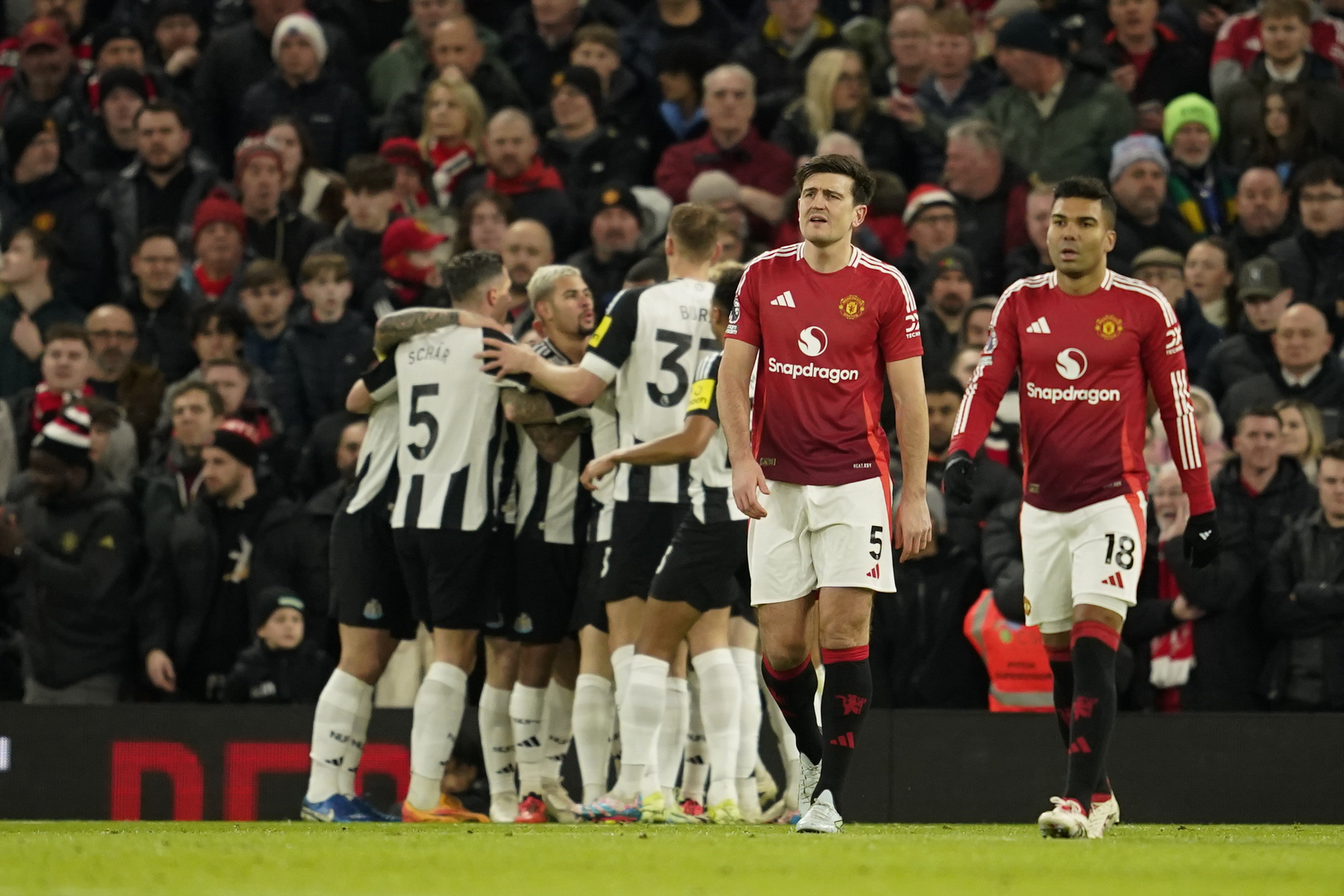 Manchester United's Harry Maguire, center, and Manchester United's Casemiro react after Newcastle's Alexander Isak scoring his side's opening goal during the English Premier League soccer match between Manchester United and Newcastle at the Old Trafford stadium in Manchester, England, Monday, Dec. 30, 2024. (AP Photo/Dave Thompson)