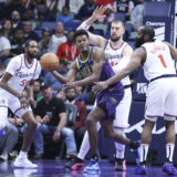 New Orleans Pelicans center Yves Missi passes the ball to a teammate while being guarded by Los Angeles Clippers center Ivica Zubac and guard James Harden (1) in the first half of an NBA basketball game in New Orleans, Monday, Dec. 30, 2024. (AP Photo/Peter Forest)