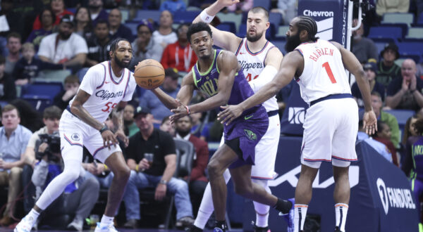 New Orleans Pelicans center Yves Missi passes the ball to a teammate while being guarded by Los Angeles Clippers center Ivica Zubac and guard James Harden (1) in the first half of an NBA basketball game in New Orleans, Monday, Dec. 30, 2024. (AP Photo/Peter Forest)