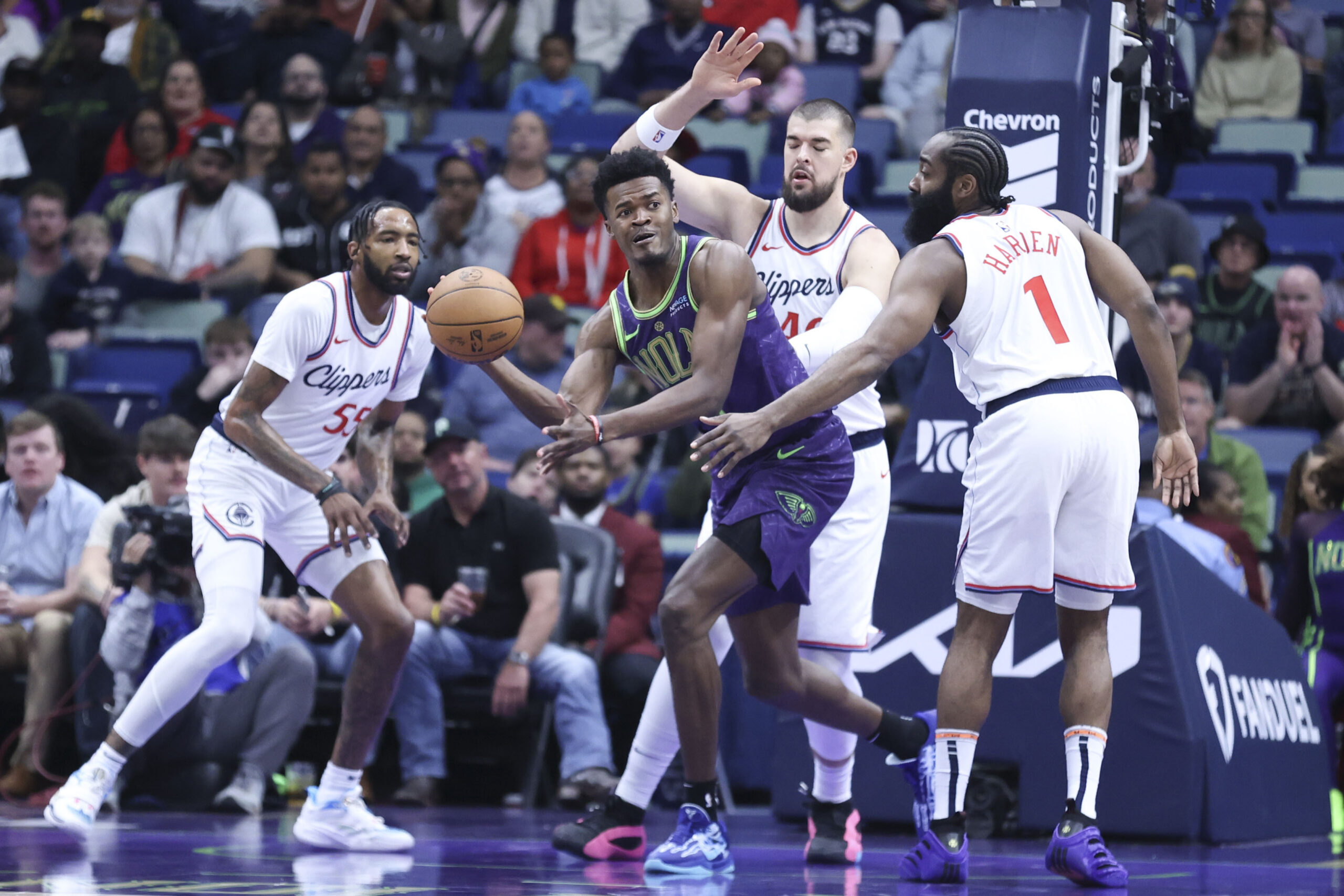 New Orleans Pelicans center Yves Missi passes the ball to a teammate while being guarded by Los Angeles Clippers center Ivica Zubac and guard James Harden (1) in the first half of an NBA basketball game in New Orleans, Monday, Dec. 30, 2024. (AP Photo/Peter Forest)