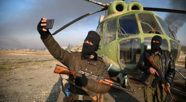 epa11752901 Armed men take selfies at the Nayrab military airport, in Aleppo, Syria, 02 December 2024. Syrian opposition forces, led by the Islamist militant group Hayat Tahrir al-Sham (HTS) launched an offensive on 27 November, taking large parts of Aleppo, Syria's second-largest city. The offensive triggered counterattacks by the Syrian regime forces as well as Russian and Syrian airstrikes on opposition-controlled areas. More than 400 people, including civilians and militants have been killed since 27 November, SOHR stated, while the United Nations Office for the Coordination of Humanitarian Affairs (OCHA) stated that over 20,000 people have been internally displaced within Aleppo and to other governorates.  EPA/BILAL AL HAMMOUD