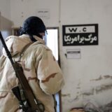 epa11754246 A member of the Syrian opposition stands next to a sign with Persian inscription reading 'Death to America' at a military position allegedly used by Iranian forces after it was captured by the Syrian opposition in the city of Khan Sheikhoun, Idlib countryside, Syria, 03 December 2024. Syrian opposition forces, led by the Islamist militant group Hayat Tahrir al-Sham (HTS), launched an offensive on 27 November, taking large parts of Aleppo, Syria's second-largest city. The offensive triggered counterattacks by the Syrian regime forces as well as Russian and Syrian airstrikes on opposition-controlled areas.  EPA/MOHAMMED AL RIFAI