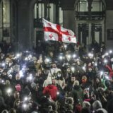 epa11760932 Supporters of the Georgian opposition hold a Georgian flag during a protest in front of the Parliament building in Tbilisi, Georgia, 06 December 2024. Thousands of pro-EU activists continue their protests in the Georgian capital against the country's ruling party decision to suspend accession talks with the European Union (EU) until the end of 2028.  EPA/DAVID MDZINARISHVILI